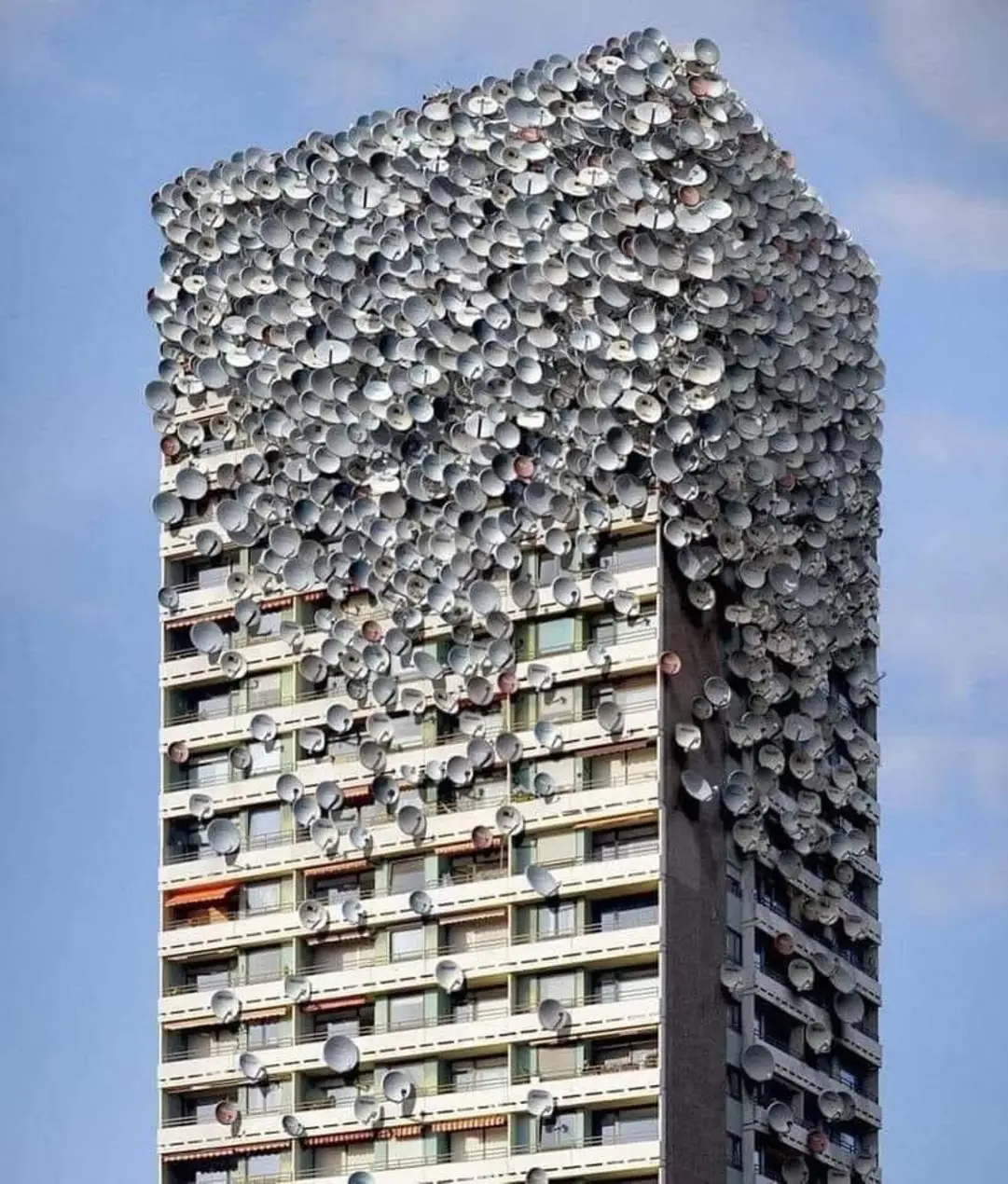 The meme is an image of a skyscraper with a massive amount of satellite dishes stacked on top of each other, covering the entire building. The text overlaid on the image is likely "I can see for miles and miles".
